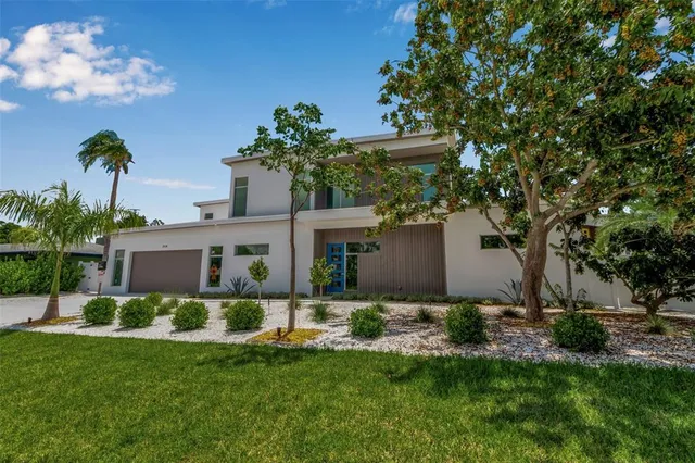 a front view of a house with a yard and potted plants