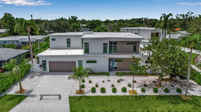 a view of a white house with a yard and potted plants