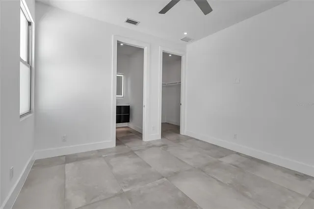 an empty room with fan and windows