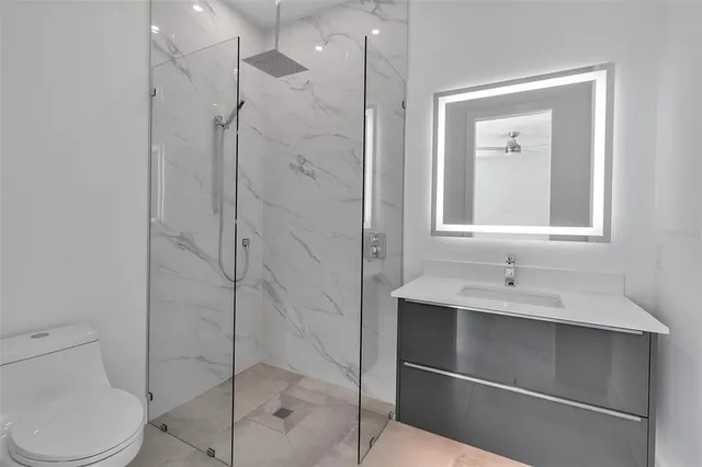 a bathroom with a sink shower and a mirror