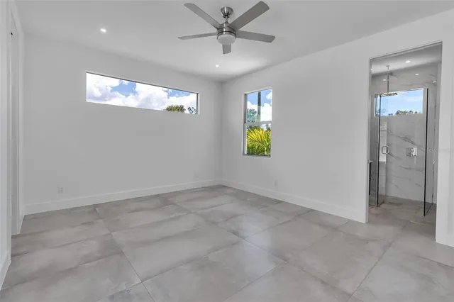 a aerial view of a white house with large windows and a small yard