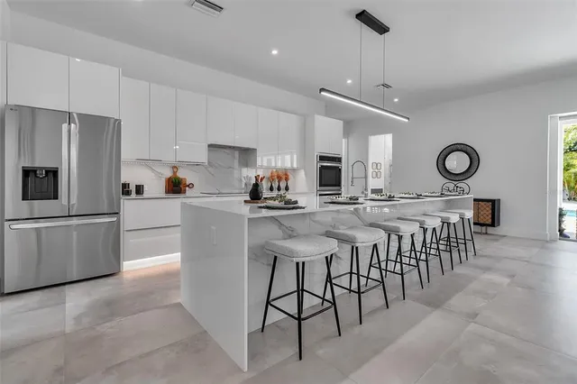 a kitchen with stainless steel appliances granite countertop a sink a stove and a wooden floors