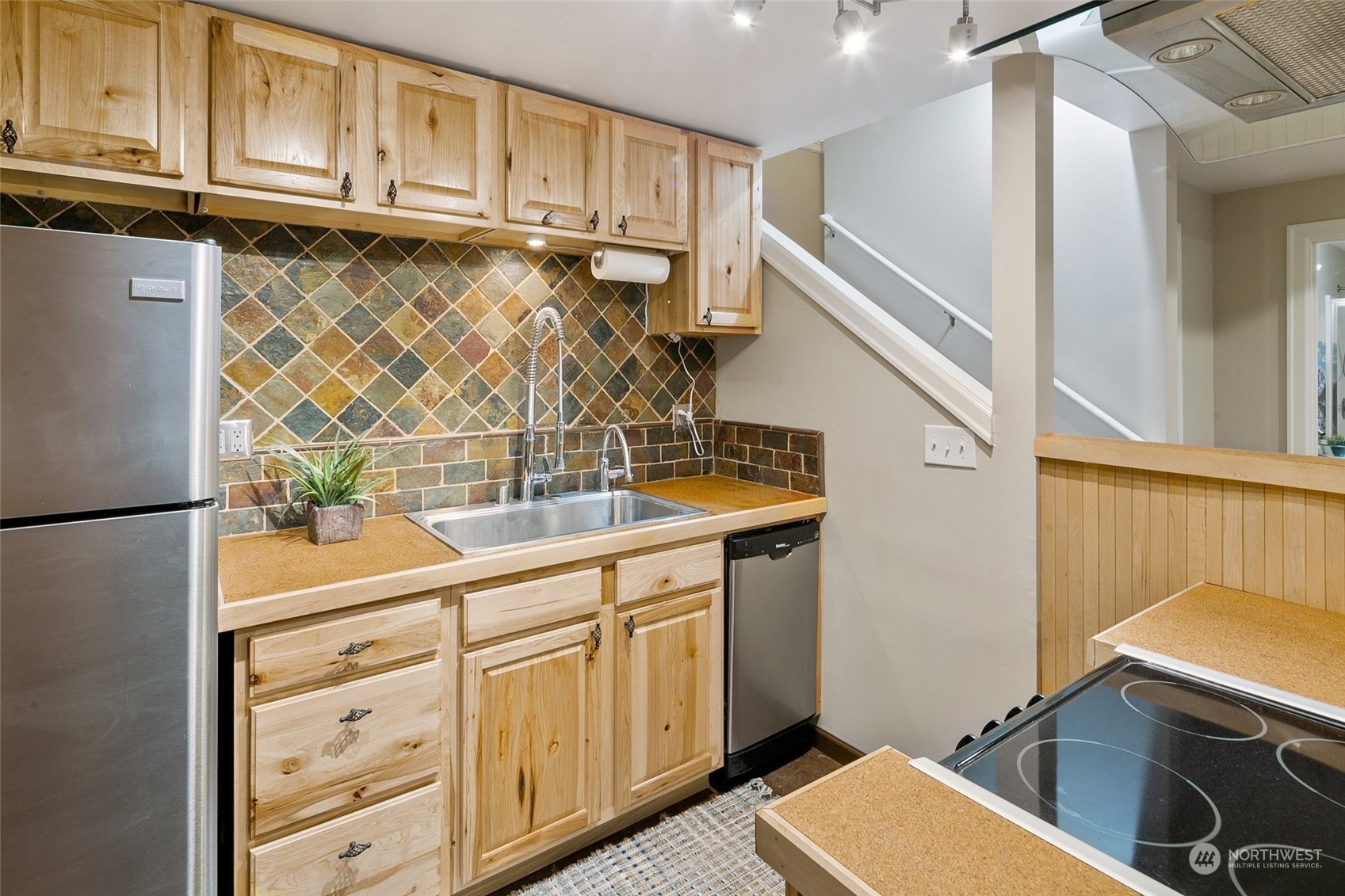 14704 Simonds Road Northeast Bothell, WA 98011 - Photo 28 of 40 a kitchen with stainless steel appliances granite countertop a sink and cabinets with wooden floor