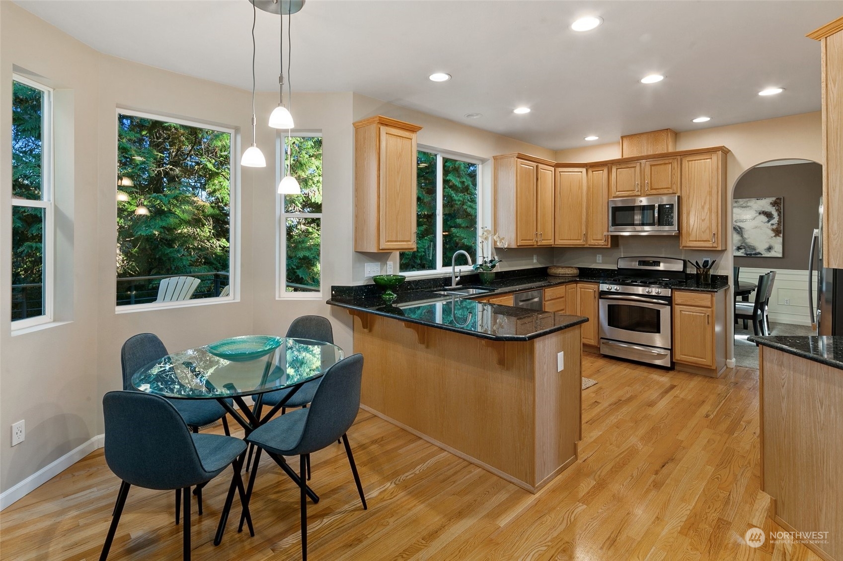 14704 Simonds Road Northeast Bothell, WA 98011 - Photo 9 of 40 a kitchen with stainless steel appliances granite countertop a stove a sink a microwave a dining table and chairs