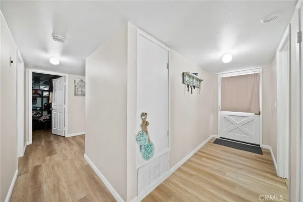 a view of a hallway with a hardwood floor and a bathroom