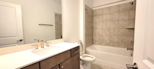 a bathroom with a sink mirror toilet and bathtub