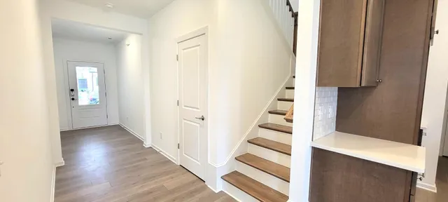 an entryway with a white walls and stairs