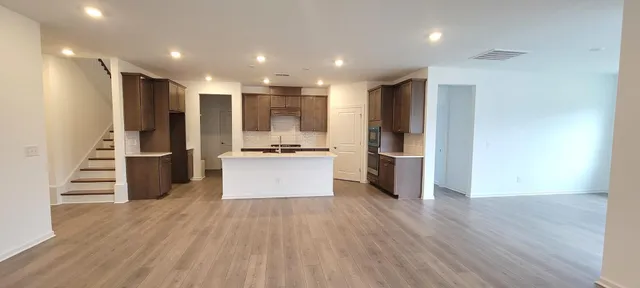 a kitchen with stainless steel appliances a refrigerator and wooden floor