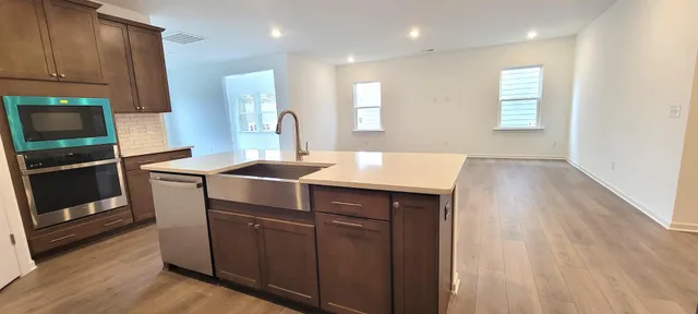 a kitchen with kitchen island white cabinets and stainless steel appliances