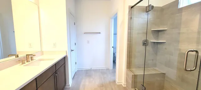 a bathroom with a granite countertop sink a mirror and a shower