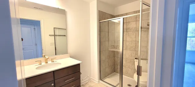 a bathroom with a shower sink and mirror