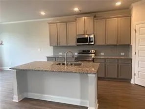 a kitchen with stainless steel appliances granite countertop a sink a stove and a refrigerator