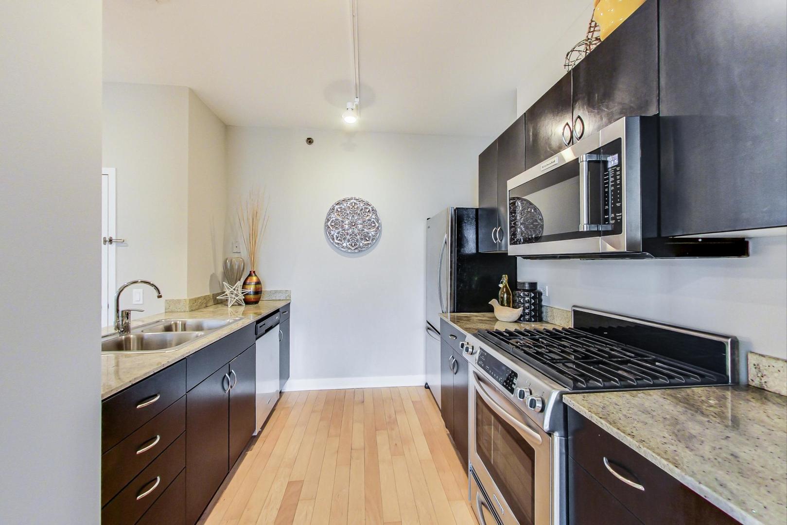 8 East Randolph Street, Unit 2207 Chicago, IL 60601 - Photo 13 of 29 a kitchen with stainless steel appliances granite countertop a stove a sink dishwasher and a refrigerator
