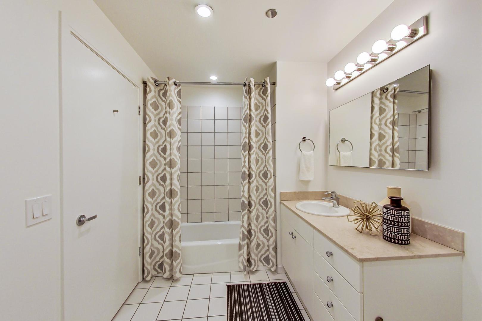8 East Randolph Street, Unit 2207 Chicago, IL 60601 - Photo 19 of 29 a bathroom with a sink a toilet a mirror a vanity and shower