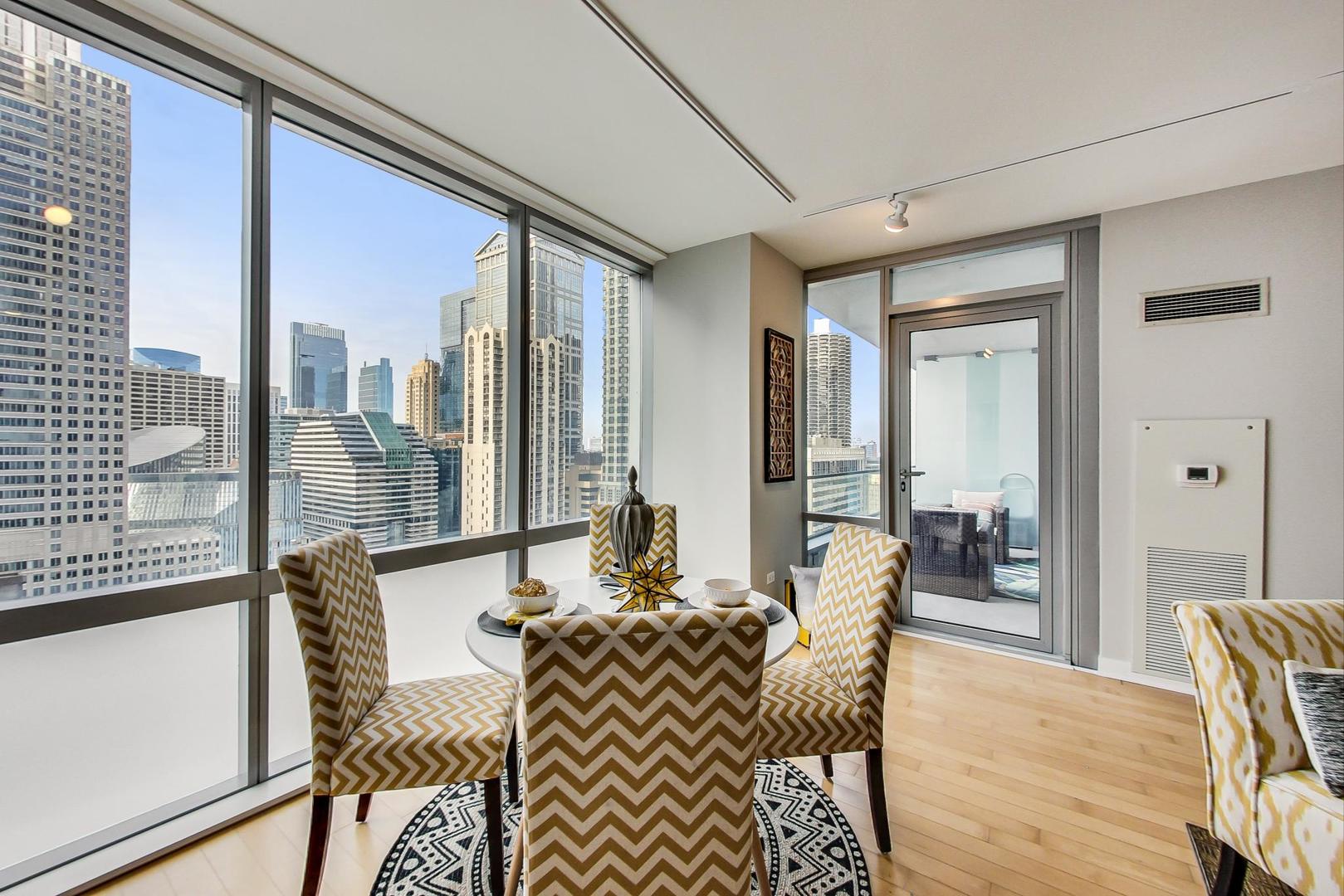 8 East Randolph Street, Unit 2207 Chicago, IL 60601 - Photo 9 of 29 a view of a dining room with furniture window and wooden floor