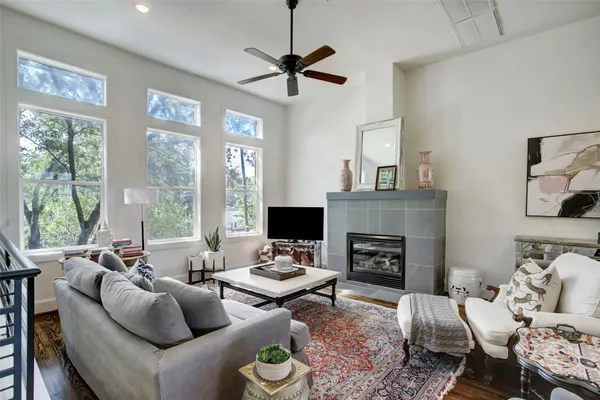 a living room with furniture a fireplace and a large window