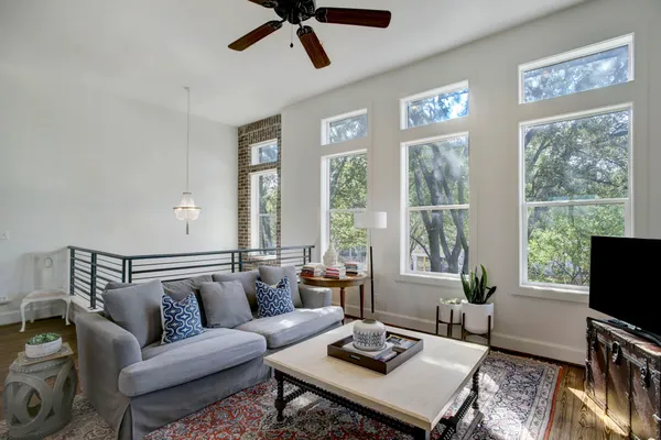 a living room with furniture a flat screen tv and a large window
