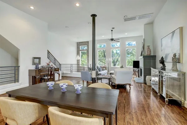 a living room with dining table chairs and wooden floor