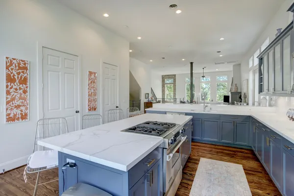 a kitchen with stainless steel appliances a stove a sink dishwasher and cabinets with wooden floor