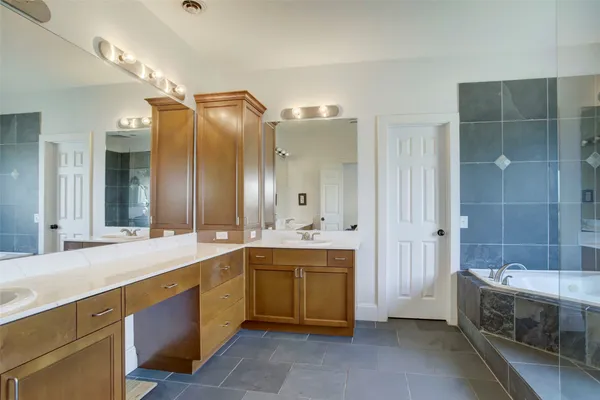 a spacious bathroom with a sink mirror and a bathtub
