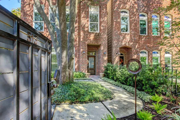 a couple of potted plants in front of brick building