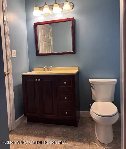 a bathroom with a toilet a sink and mirror