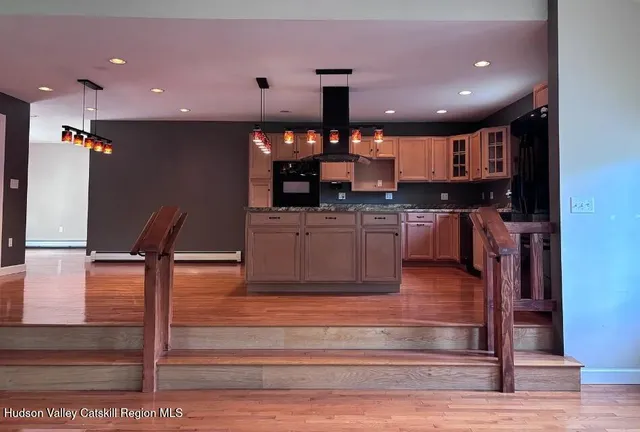 a kitchen with stainless steel appliances kitchen island granite countertop a stove and a sink