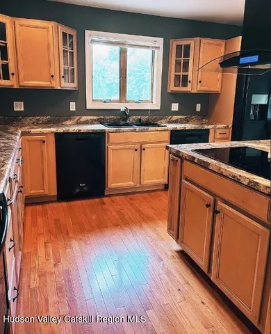 a kitchen with stainless steel appliances granite countertop wooden cabinets a sink a stove a dining table and chairs