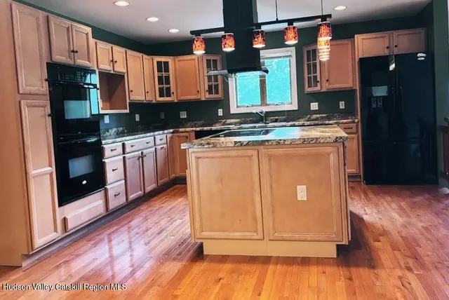 a kitchen with stainless steel appliances granite countertop a refrigerator a stove a sink and a microwave