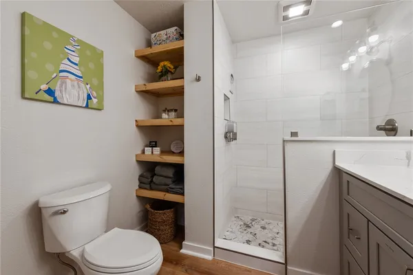 a bathroom with a toilet a sink and glass door