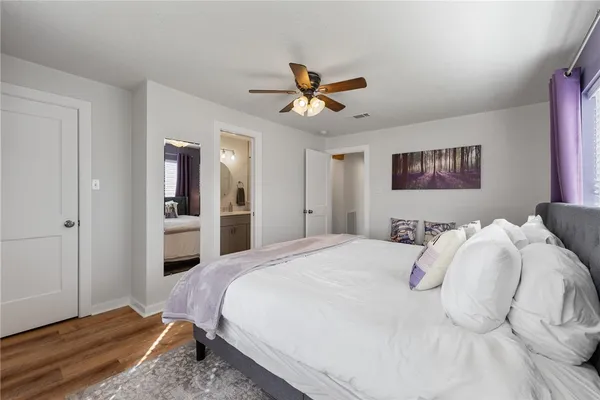 a spacious bedroom with a bed and a chandelier