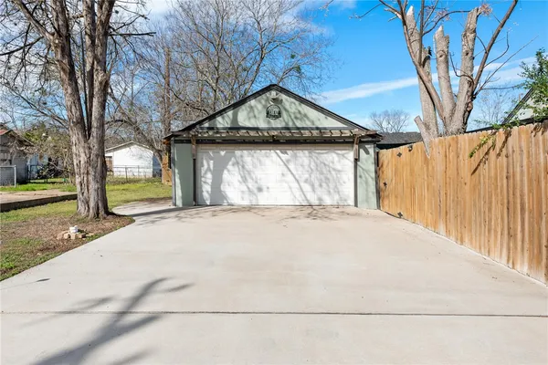 a view of wooden house with a yard and large trees