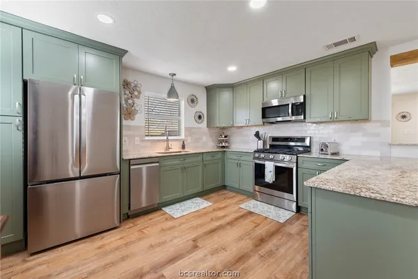 a kitchen with granite countertop stainless steel appliances and wooden cabinets