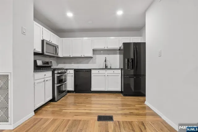 a kitchen with stainless steel appliances granite countertop a refrigerator stove and a sink
