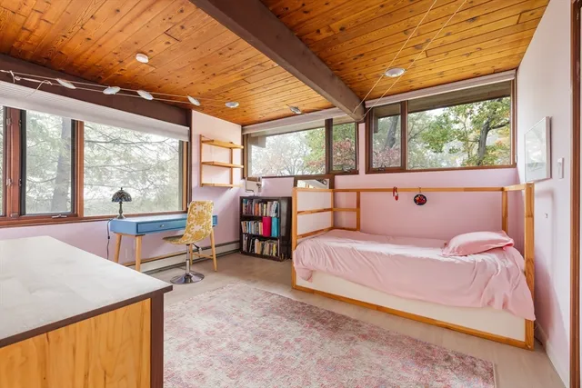 a bedroom with a bed and large windows