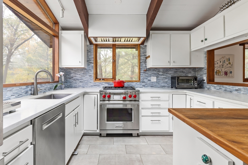 134 Rangeley Road Brookline, MA 02467 - Photo 4 of 20 a kitchen with stainless steel appliances granite countertop a sink window and cabinets