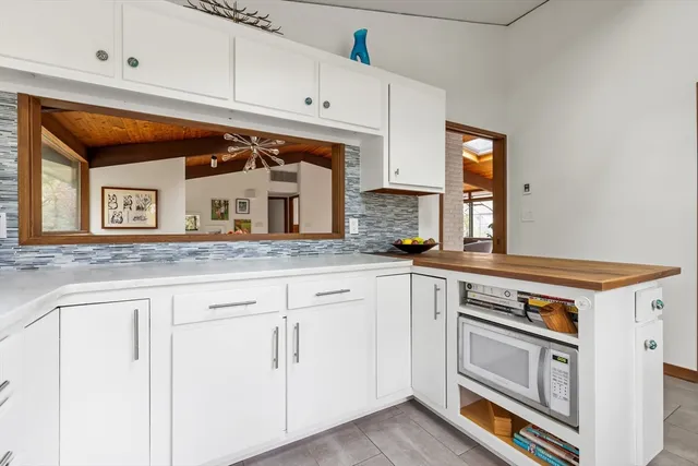 a kitchen with granite countertop white cabinets and white appliances