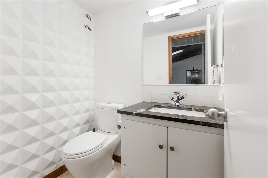 134 Rangeley Road Brookline, MA 02467 - Photo 8 of 20 a bathroom with a granite countertop sink a toilet and a mirror