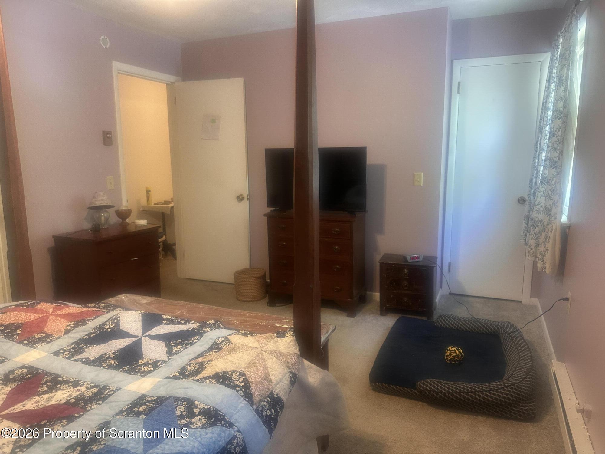 107 Keystone Hls Road, Unit 405 Factoryville, PA 18419 - Photo 23 of 27 a bedroom with a bed and a mirror