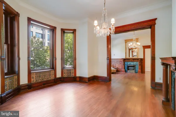 a view of a livingroom with wooden floor and a ceiling fan