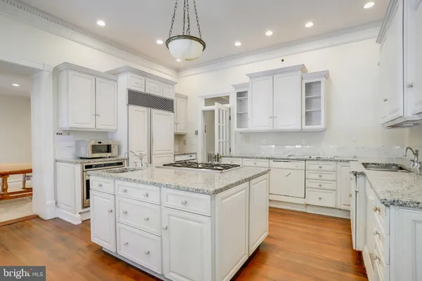 an empty room with wooden floor fireplace and windows