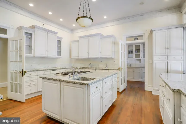 a view of an empty room with wooden floor and a fireplace