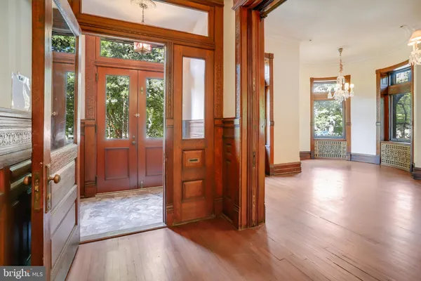 a view of a hallway with wooden floor and chandelier
