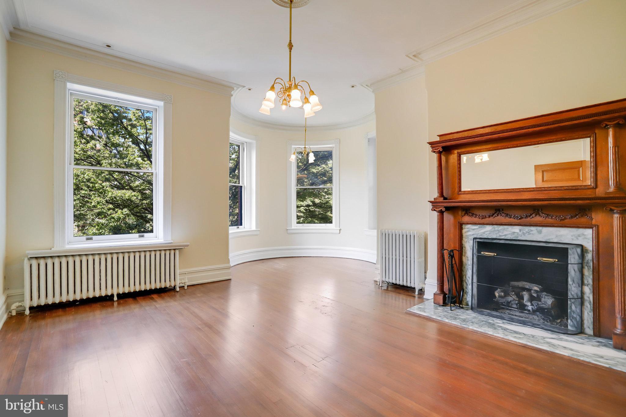 1633 16th Street Northwest Washington, DC 20009 - Photo 41 of 130 a view of an empty room with wooden floor fireplace and a window