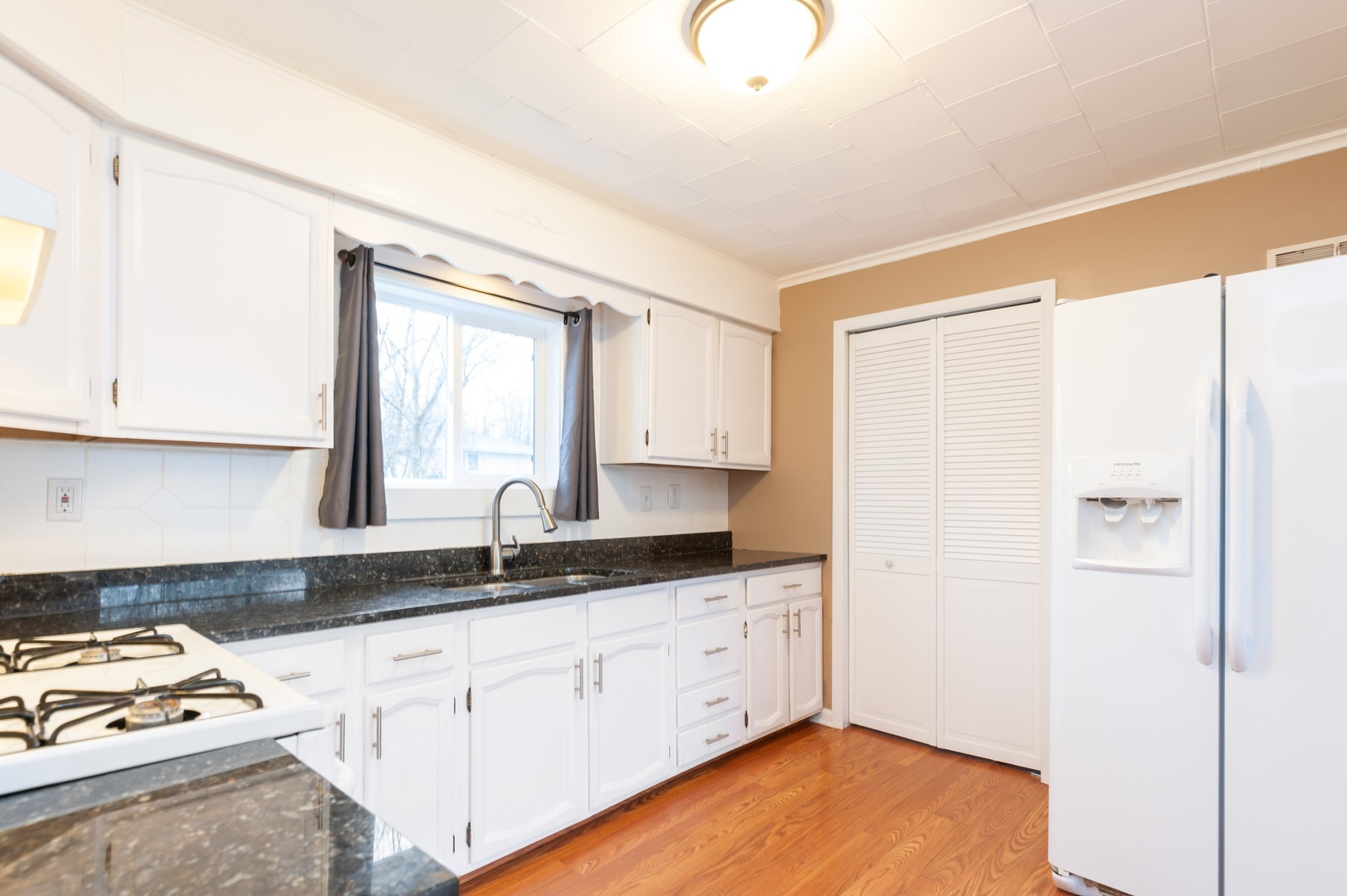 310 Rand Road Lakemoor, IL 60051 - Photo 4 of 10 a kitchen with granite countertop a sink cabinets and a window
