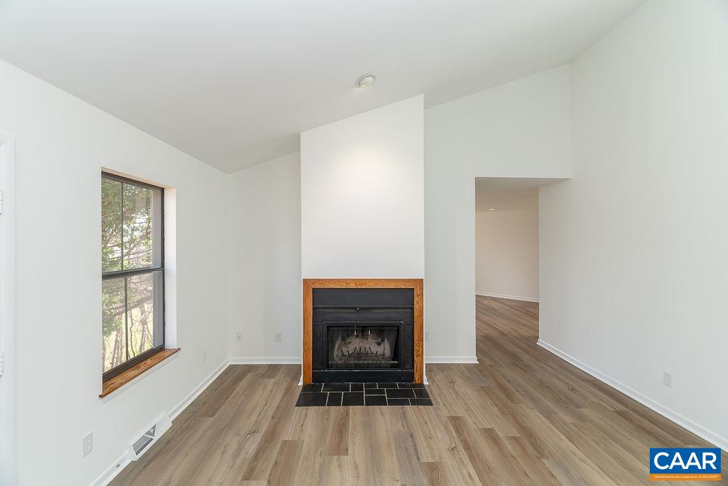 751 Exton Court Charlottesville, VA 22901 - Photo 13 of 42 a view of an empty room with wooden floor fireplace and a window