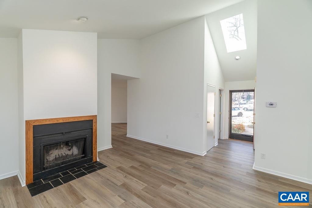 751 Exton Court Charlottesville, VA 22901 - Photo 9 of 42 an empty room with wooden floor a fireplace and windows