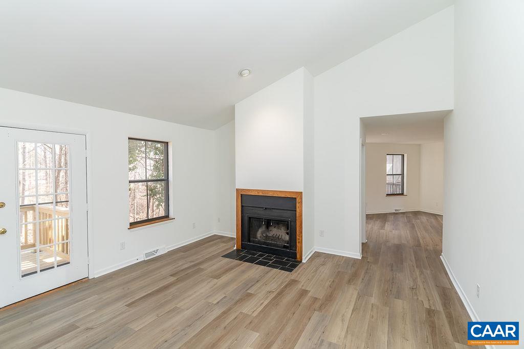 751 Exton Court Charlottesville, VA 22901 - Photo 10 of 42 an empty room with wooden floor fireplace and windows