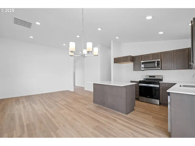 a kitchen with kitchen island a counter top space appliances and cabinets