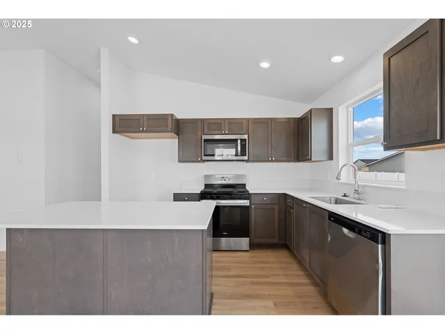 a kitchen with stainless steel appliances granite countertop a sink stove and refrigerator